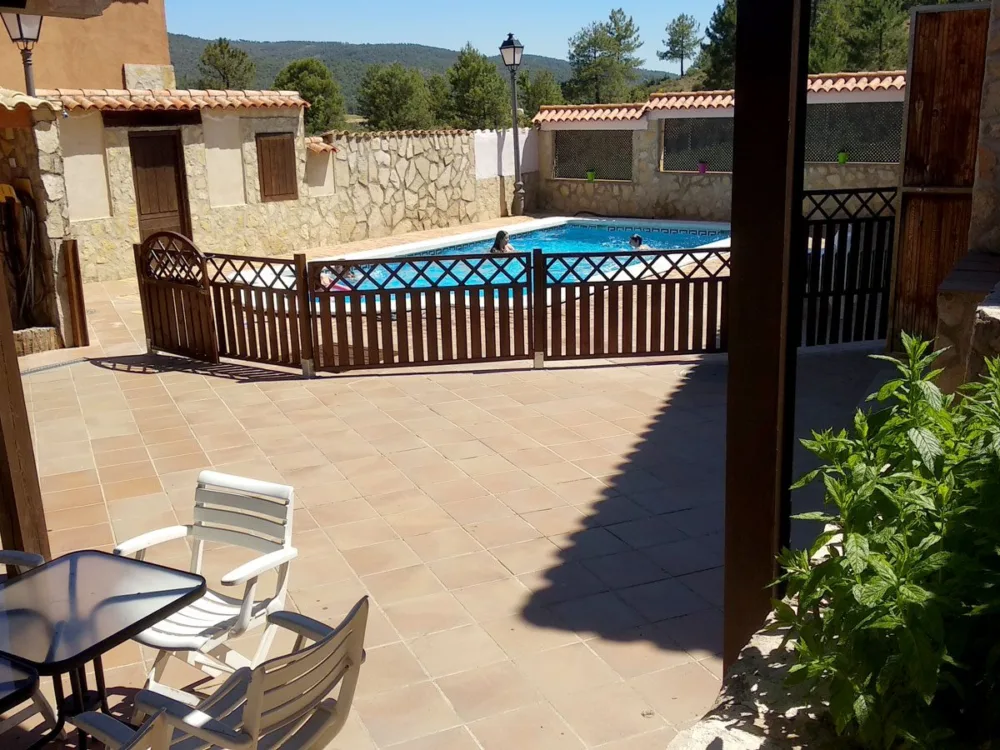 Porche de una casa con la piscina al fondo